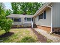 Charming home entrance with a welcoming porch, lovely landscaping, and a well-maintained front yard at 1915 Redding Ln, Durham, NC 27712