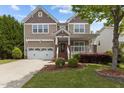 Charming home with a well-manicured front yard and a cozy porch with white railings at 1928 Grace Point Rd, Morrisville, NC 27560