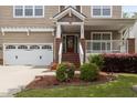 Inviting home exterior with a two-car garage and covered porch with brick and white pillars at 1928 Grace Point Rd, Morrisville, NC 27560