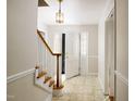 Inviting foyer with staircase and stylish light fixture adds charm at 2021 Sunnybrook Dr, Burlington, NC 27215