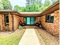 Inviting brick front porch with double doors, chairs, and a well-manicured walkway at 2100 Possum Trot Rd, Wake Forest, NC 27587
