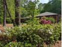 Beautiful landscaping with blooming bushes and mature trees near the home at 2100 Possum Trot Rd, Wake Forest, NC 27587