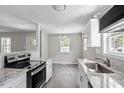 Modern kitchen featuring granite countertops, stainless steel appliances, and stylish gray flooring at 2222 Oak Ridge Blvd, Durham, NC 27707