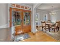 Elegant foyer featuring hardwood floors, a dining room view, and a beautiful wooden double-door entrance at 2723 Cameron Pond Dr, Cary, NC 27519