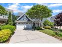 Inviting blue two-story home featuring a spacious driveway and a well-maintained front yard with mature trees at 2723 Cameron Pond Dr, Cary, NC 27519