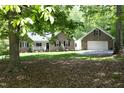 Beautiful brick home with an attached garage surrounded by lush trees and a meticulously kept lawn at 320 Delvin Lane Ln, Hillsborough, NC 27278