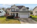 Charming two-story home featuring an attached two-car garage and traditional architectural details at 323 Windgate Dr, Clayton, NC 27527