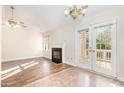 Living room with fireplace and doors that lead to deck with natural light at 3325 Tarleton E, Durham, NC 27713