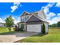 Attractive two-story home featuring a spacious two-car garage and lush, green landscaping at 47 Peduncle St, Selma, NC 27576