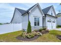 Well-maintained home featuring flower beds, a white fence, and a two-car garage at 49 Kathy Mae Ct, Angier, NC 27501