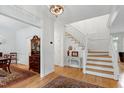 Bright foyer showcasing hardwood floors, elegant staircase, and decorative furnishings leading to the dining area at 5112 Wolcott Ct, Fuquay Varina, NC 27526