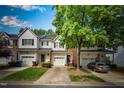 Traditional townhomes featuring attached garages, and landscaped front yards under a blue sky at 5547 Sea Daisy Dr, Raleigh, NC 27606