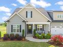 Attractive home featuring a covered porch, well-kept lawn, and a two-car garage at 60 Heart Pine Dr, Wendell, NC 27591