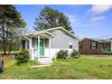 Charming single story home with grey siding, a white brick foundation, and a bright green front door at 607 E Granville St, Dunn, NC 28334