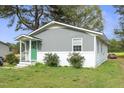Charming single story home with grey siding, a white brick foundation, and a bright green front door at 607 E Granville St, Dunn, NC 28334