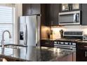 Modern kitchen with stainless steel appliances, granite countertops, and dark wood cabinets at 616 Dorothea Dr, Raleigh, NC 27603