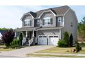 Charming two-story home with gray siding, a well-manicured lawn, and a two-car garage at 638 Boulder Point Dr, Chapel Hill, NC 27516