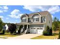 Charming gray two-story home featuring a manicured lawn and a convenient two-car garage at 638 Boulder Point Dr, Chapel Hill, NC 27516