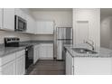 Bright kitchen featuring stainless steel appliances, granite countertops, and white cabinetry at 704 Shepard Rock Dr, Zebulon, NC 27597