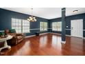 Spacious living room featuring dark blue walls, white trim, hardwood floors, and plenty of natural light at 8300 Neuse Hunter Dr, Raleigh, NC 27616