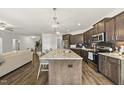 Modern kitchen featuring stainless steel appliances, a center island, and hardwood floors at 86 Buckhaven Ct, Holly Springs, NC 27540