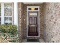 A welcoming front door with brick surround and decorative sidelight providing curb appeal at 9207 Wooden Rd, Raleigh, NC 27617