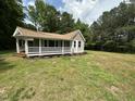 Inviting cottage-style home featuring a covered porch and well-maintained lawn at 10017 Oakley Rd, Zebulon, NC 27597