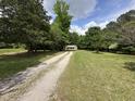 Quaint cottage-style home nestled among mature trees and long gravel driveway at 10017 Oakley Rd, Zebulon, NC 27597