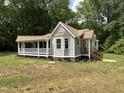 Charming cottage-style home with a covered porch, new grass and manicured landscaping at 10017 Oakley Rd, Zebulon, NC 27597