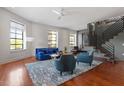 Bright living room with large windows, a stylish blue sofa, hardwood floors, and modern furnishings at 101 Morris St # D, Durham, NC 27701