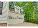 White two car garage with windows on top, surrounded by mature trees at 105 Parkmount Cir, Cary, NC 27519
