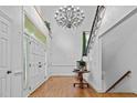 Elegant foyer with hardwood floors, a grand chandelier, and a staircase with iron railings at 106 Birkhaven Dr, Cary, NC 27518