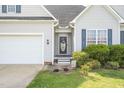 Inviting entrance with a decorative front door, complemented by blue shutters and blooming plants at 106 Jj Dr, Benson, NC 27504
