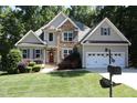 Beautiful home with stone and gray siding, a two-car garage, manicured lawn, and colorful landscaping at 1108 Kalworth Rd, Wake Forest, NC 27587