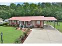 Well-maintained home with a red metal roof, green lawn, and concrete driveway at 113 Gulf Drive Dr, Dunn, NC 28334
