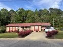 Inviting single-story home featuring a red metal roof and beautiful rose bushes at 113 Gulf Drive Dr, Dunn, NC 28334