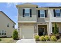 Charming townhome featuring a stone facade, attached garage, and manicured landscaping at 1141 Amber Shadow Dr # 101, Durham, NC 27703