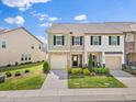 Charming townhome featuring a stone facade, attached garage, and well-manicured landscaping at 1141 Amber Shadow Dr # 101, Durham, NC 27703