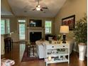 Bright living room with vaulted ceilings, a cozy fireplace, hardwood floors, and ample natural light at 115 Oak Leaf Trl, Youngsville, NC 27596