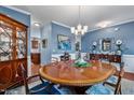 This dining room features warm wood floors, a large table, elegant decor, and sophisticated blue walls at 1287 Salters St, Burlington, NC 27215