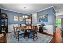 Elegant dining room with wainscoting, beautiful blue walls, hardwood floors, and a stylish chandelier at 1287 Salters St, Burlington, NC 27215
