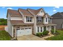 Beautiful two-story home featuring a two-car garage, well-maintained lawn, and covered front porch at 135 Campaign Dr, Mebane, NC 27302
