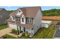 Lovely two-story home with manicured lawn, two-car garage, and a charming covered front porch at 135 Campaign Dr, Mebane, NC 27302