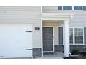 Exterior featuring a gray front door with a brick facade and two-car garage at 139 Palm Drive Dr, Sanford, NC 27332