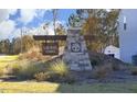 Community sign for Laurel Oaks, featuring stone pillar and professionally landscaped entrance at 139 Palm Drive Dr, Sanford, NC 27332