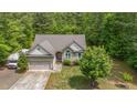 A lush green yard surrounds this one-story home with an attached garage and large driveway at 175 Grist Mill Dr, Franklinton, NC 27525