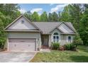 Lovely one-story home with green siding, attached garage, and beautiful landscaping at 175 Grist Mill Dr, Franklinton, NC 27525