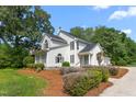 Charming white home with lush landscaping, a manicured lawn and a welcoming driveway at 1925 W Lake Dr, Burlington, NC 27215