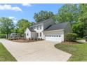 Side view of a two-story white home with a large driveway leading to an attached garage at 1925 W Lake Dr, Burlington, NC 27215