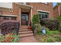 Inviting front entrance with brick steps, manicured landscaping, and a welcoming wreath on the door at 213 Old Franklin Grove Dr, Chapel Hill, NC 27514